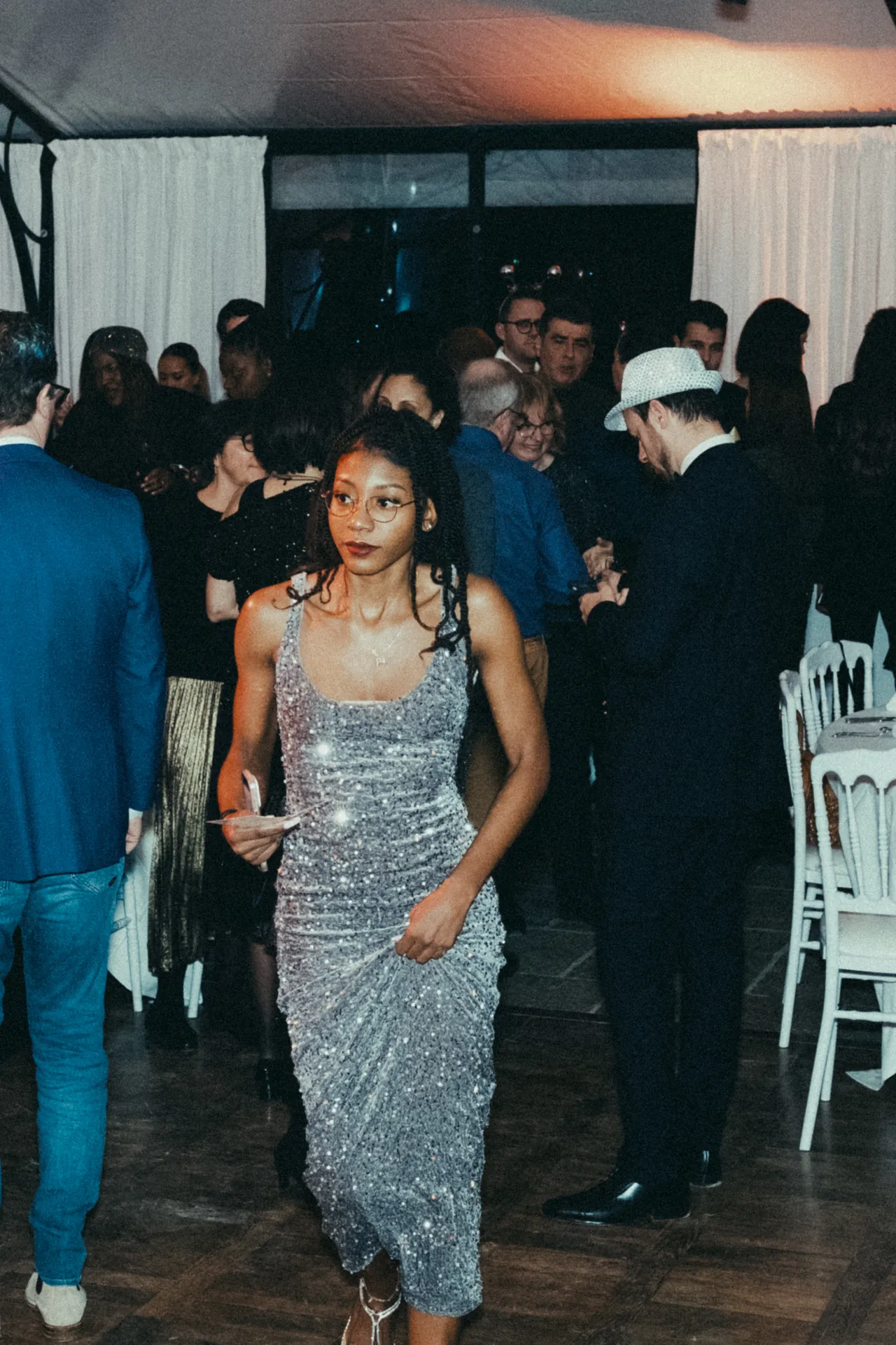 Une jeune femme vêtue d'une robe avec des paillettes est photographiée par Jeremy Dan lors d'un séminaire d'entreprise.