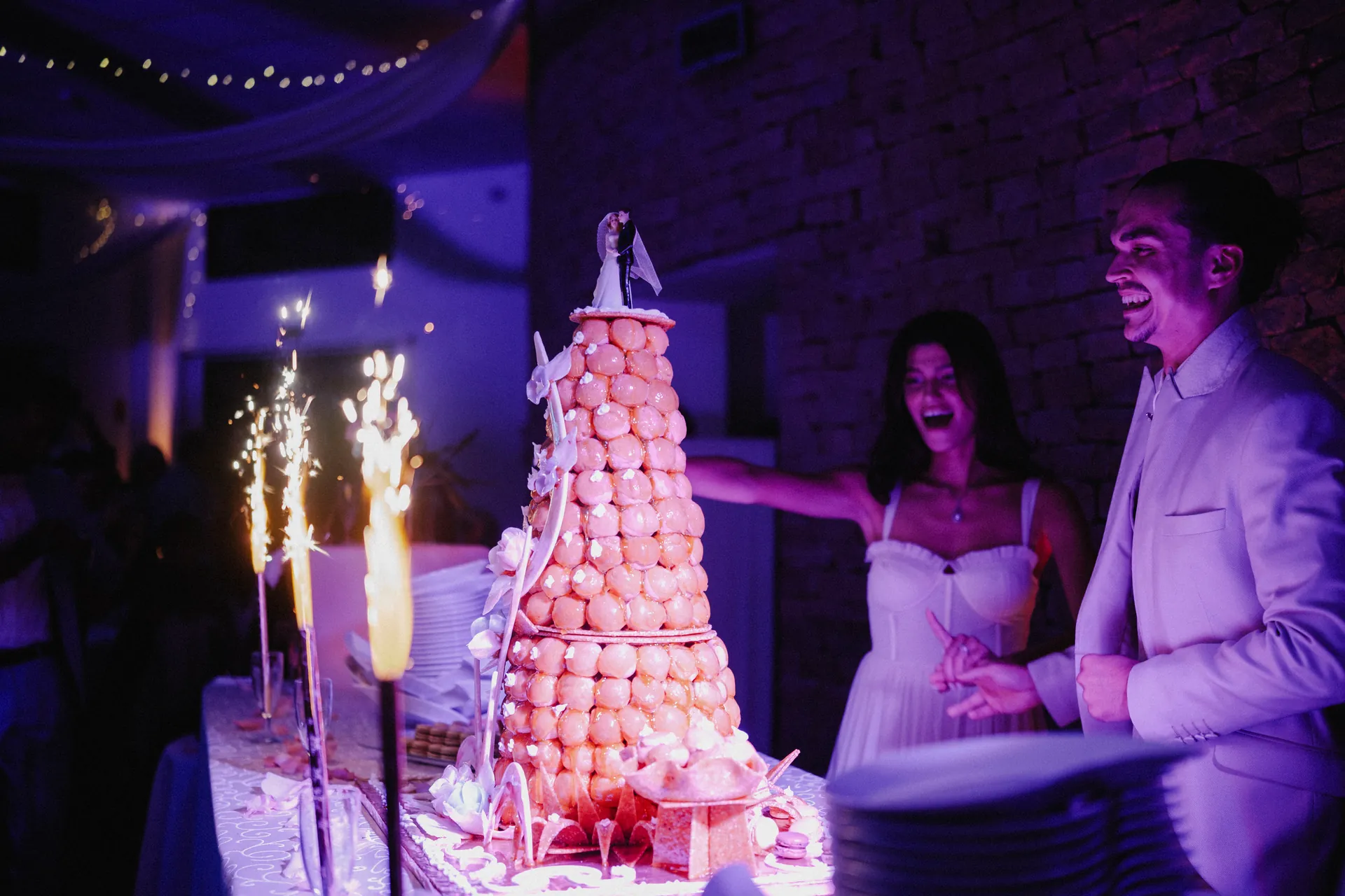 Le marié et la mariée admirent leur gâteau de mariage lors de la soirée dansante dans un domaine.