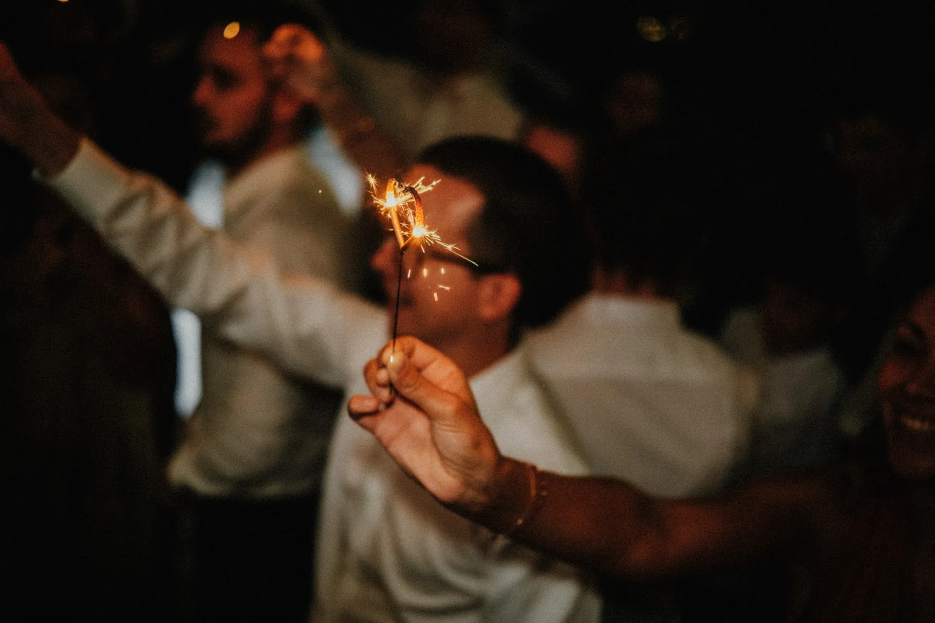 Une main tient élégamment plusieurs cierges en métal en forme de cœur sur un fond sombre. Capturé par Jeremy Dan, photographe et vidéaste de mariage à Sceaux, Hauts-de-Seine.